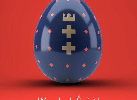 Grafika przedstawia granatowe jajko. Wewnątrz od góry korona i poniżej dwoma krzyżami. Poniżej napis Wesołych Świąt!