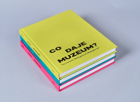 Na zdjęciu trzy książki ułożone jedna na drugiej. Na okładce napis "Co daje Muzeum?"
