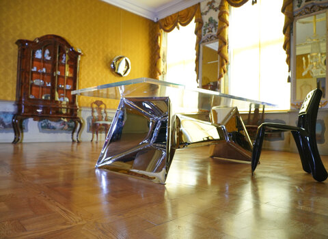 Designerski stół ze szklaną taflą we wnętrzach dawnej sypialni w Domu Uphagena.