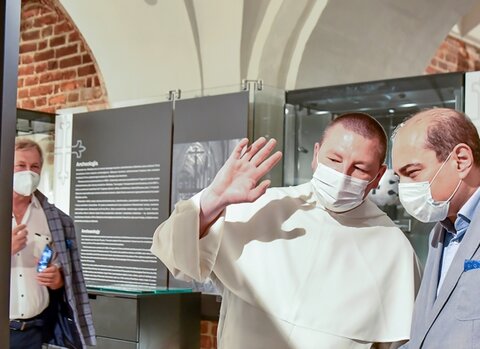 Michał Osek (OP) z lewej oraz Basil Kerski na salach wystawowych Galerii Palowej. Z lewej fragment instalacji z witrażami. 