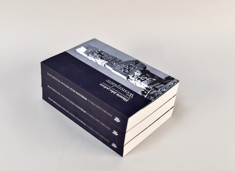 Zdjęcie. Trzy książki w kolorze granatowym leżące na sobie. Na grzbietach tytuł "Historia jako pokusa. Spojrzenie przez pryzmat Westerplatte". Na okładce po prawej stronie bryła Pomnika Obrońców Wybrzeża na Westerplatte.   