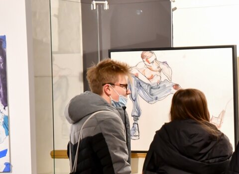 Zdjęcie. Młodzież na sali wystawowej. Oglądają obrazy. 