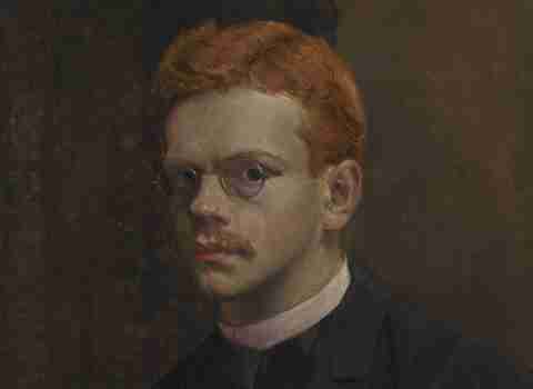Portret młodego, rudowłosego mężczyzny w okularach.  