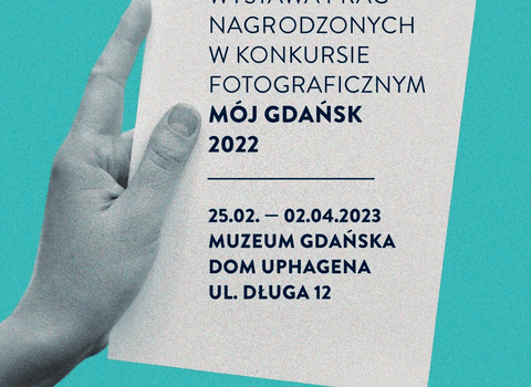 Grafika wystawy Mój Gdańsk 2022. Na grafice dłoń trzymająca kartkę papieru z nazwą, miejscem i terminem trwania wystawy. 