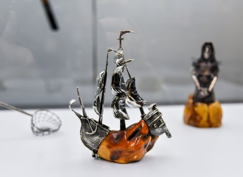 Na zdjęciu miniatura gdańskiej kogi wykonana z oksydowanego srebra. Środkowa część statku wykonana jest z miodowej bryłki bursztynu. 