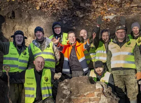 Zdjęcie. Grupa archeologów stojąca w otoczeniu pozostałości grobu Nataniela Wolfa. 