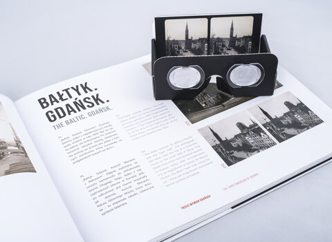 Zdjęcie. Otwarta książka, w środku stare zdjęcia Gdańska. Na otwartej stronie leżą okulary stereoskopowe.