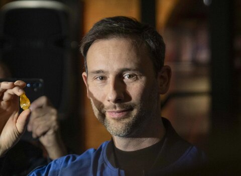 dr Sławosz Uznański-Wiśniewski z bryłką bursztynu "Kos'em"