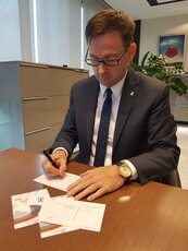 Prezes Daniel Obajtek podpisuje Kartki dla Powstańców.jpg