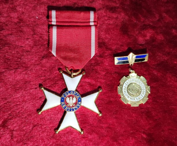 Zdjęcie przedstawia leżące Order Polonia Restituta w kształcie gwieździstego krzyża, w środku Orzeł Biały i kolisty medal.
