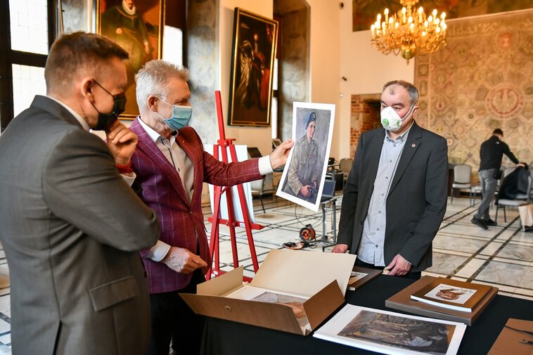 Na zdjęciu od lewej Waldemar Ossowski i Karol Klukowski oglądają prace prezentowane w Tece Gdańskiej. Po prawej Jacek Borzych. W tle obrazy i okna. 