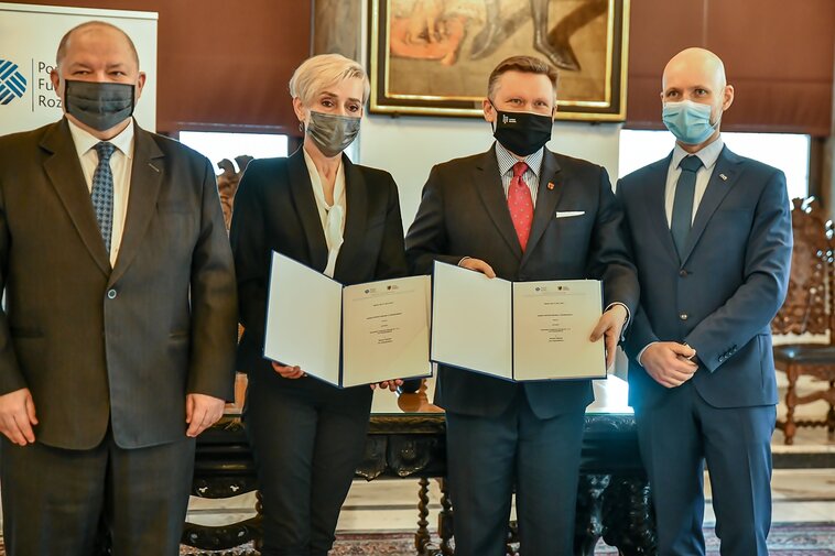 Zdjęcie. Od lewej Wiesław Byczkowski, Wicemarszałek Województwa Pomorskiego, Irena Wróblak, Prezes Zarządu Pomorskiego Funduszu Rozwoju, Waldemar Ossowski, dyrektor Muzeum Gdańska oraz i Alan Aleksandrowicz, z-ca Prezydenta Gdańska prezentują podpisaną umowę. 