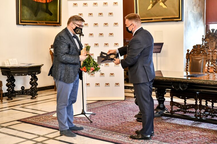 Zdjęcie. Wielka Sala Wety Ratusza Głównego Miasta. Prof. Jacek Szwedo (z lewej) otrzymuje Medal Muzeum Gdańska od Waldemara Ossowskiego (z prawej).