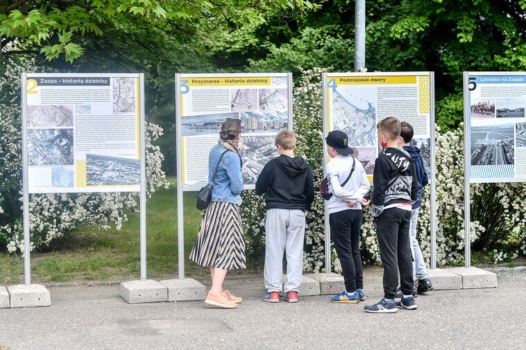 Zdjęcie. Przestrzeń. Ludzie wokół wystawy plenerowej. Zaspa-Młyniec. 