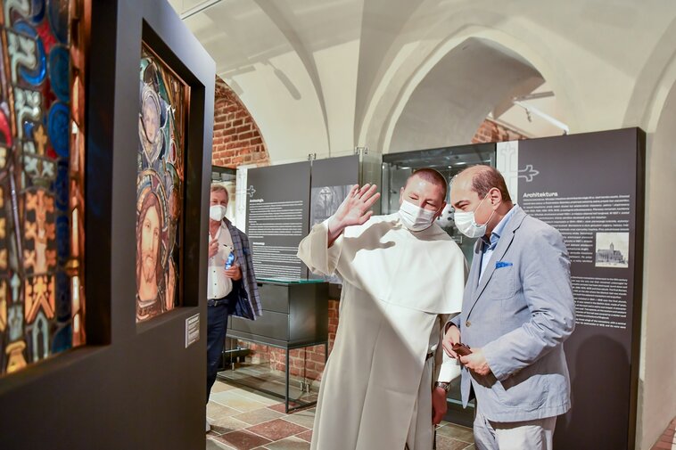 Michał Osek (OP) z lewej oraz Basil Kerski na salach wystawowych Galerii Palowej. Z lewej fragment instalacji z witrażami. 