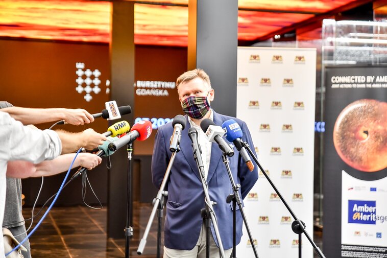 Zdjęcie. Waldemar Ossowski. W tle pomieszczenie Wielkiego Młyna. 
