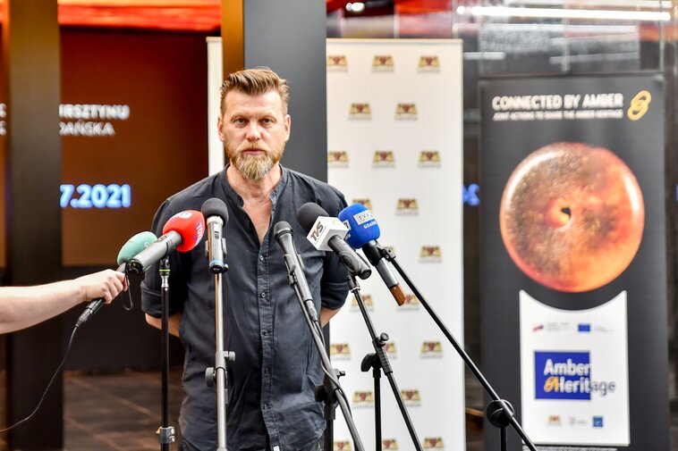 Zdjęcie. Robert Sochacki. W tle pomieszczenie Wielkiego Młyna. 