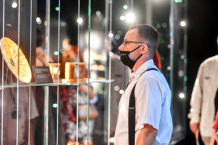 Na przedpremierowy pokaz nowego Muzeum przybyli przedstawiciele wielu środowisk zaangażowanych w powstanie Muzeum Bursztynu. Zdjęcie. Widz oglądaja wystawę. W gablotach eksponaty.