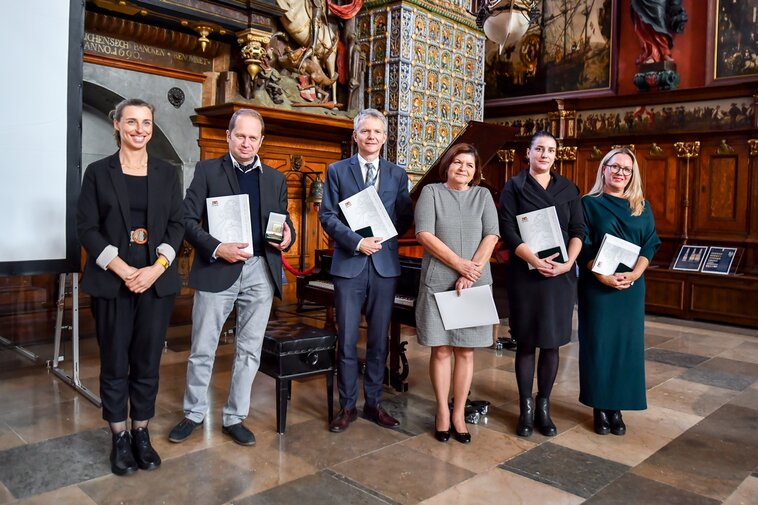 Od lewej Monika Chabior, Marek Adamkowicz, Janusz Marszalec, Elżbieta Miłosierna, Kinga Krause oraz Ewa Joszczak. Prezentują Medale Prezydenta Miasta Gdańska. 