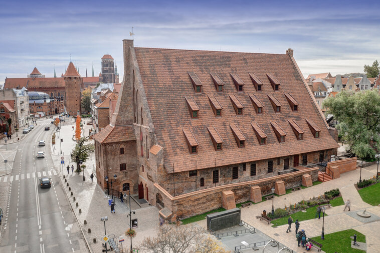 Zdjęcie przedstawia widok na ulice Starego Przedmieścia z lotu ptaka. W centrum znajduje się bryła Wielkiego Młyna ze spadzistym dachem i opływający go Kanał Raduni. 