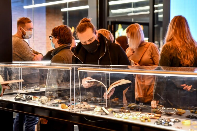 Zdjęcie. Widzowie oglądają eksponaty w gablotach w Muzeum Bursztynu. 