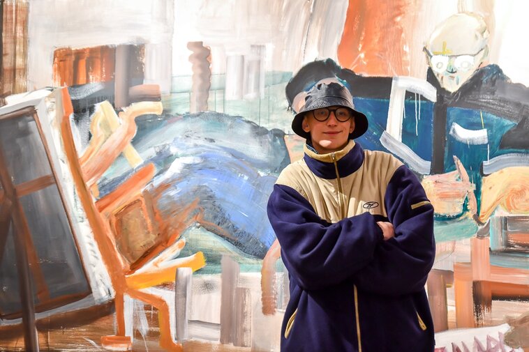 Zdjęcie. Edward Pytlos na tle autorskiego grafitti. 