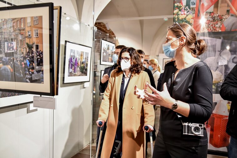 Zdjęcie. Aleksandra Dulkiewicz (z lewej) wraz z Karoliną Misztal (z prawej) ogląda fotografie prezentowane w Galerii Palowej Ratusza Głównego Miasta. 