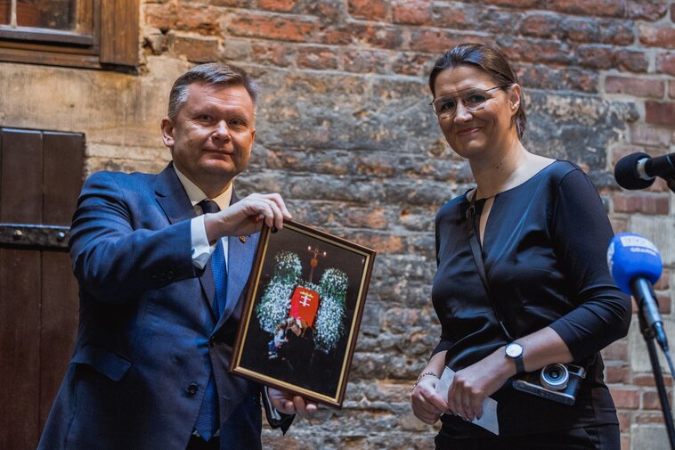 Zdjęcie. Waldemar Ossowski (z lewej) prezentuje wraz z Karoliną Misztal (z prawej) przekazane do zbiorów Muzeum Gdańska zdjęcie. 