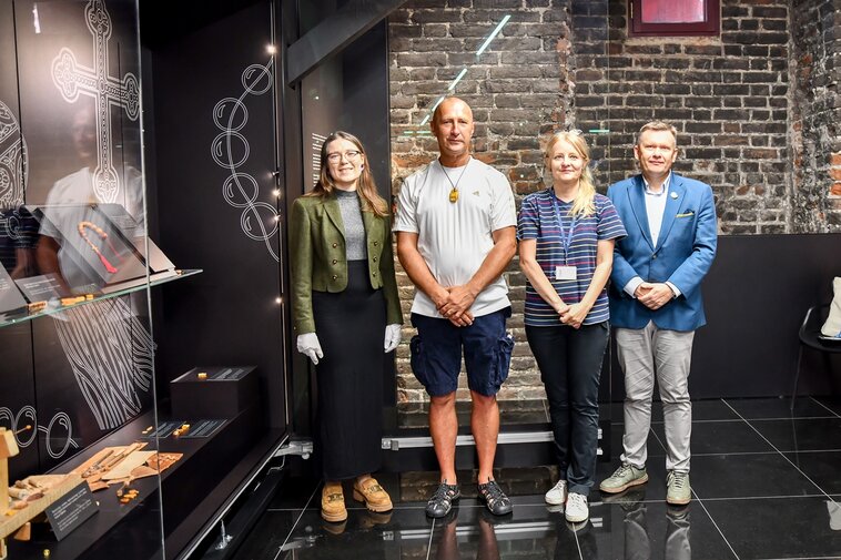 Od lewej Julia Hladiy, Grzegorz Gadomski, Joanna Grążawska i Waldemar Ossowski w Muzeum Bursztynu. Po lewej gablota ze średniowiecznymi przedmiotami.  