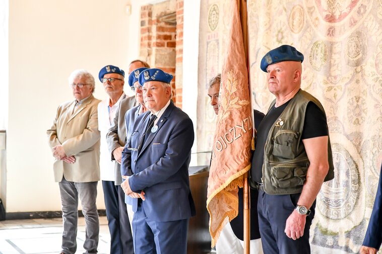 Zdjęcie. "Niebieskie berety" w Muzeum Gdańska. St. szer. Piotr Kammer trzyma sztandar. 