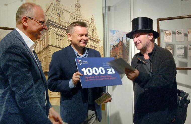 Tadeusz Zając (po prawej), otrzymuje z rąk Waldemara Ossowskiego (w środku) nagrodę w wysokości 1000 zł. 