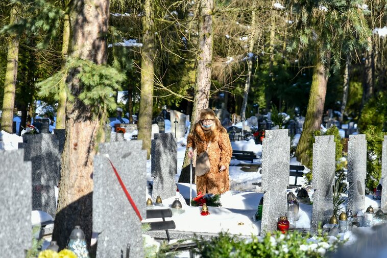 Gdańscy seniorzy, potomkowie gdańskich AK-owców porządkują Kwaterę AK na Cmentarzu Łostowickim. Na zdjęciu jedna z seniorek wokół grobów.  