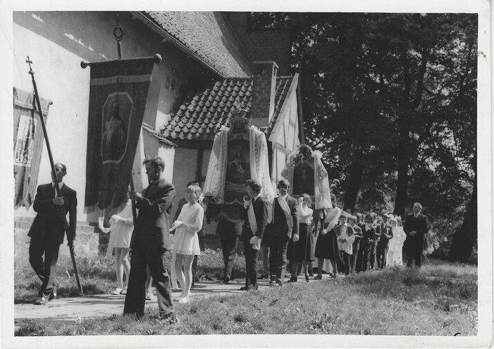 procesja Bożego Ciała na Matarni ok. 1970 roku. Na zdjęciu uczestnicy procesji idą wzdłuż białego budynku, najprawdopodobniej kościoła. 