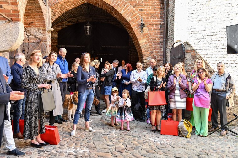 Uczestnicy wernisażu na dziedzińcu Zespołu Przedbramia. 