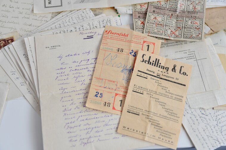 Dokumenty, ulotki z zakładu optycznego i bilety z okresu 1919-1939. Po lewej list w języku niemieckim. Rozpoczęcie listu to zawołanie w języku polskim "Mój skarbie złoty!"  