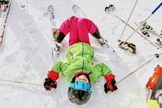 large_web-and-screen-high-angle-view-of-child-with-skis-laying-down-on-the-snow-1-jpg