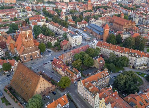 Zdjęcie przedstawia widok na ulice Starego Przedmieścia z lotu ptaka. W centrum znajdują się ulice. W lewym dolnym roku znajduje się bryła Wielkiego Młyna ze spadzistym dachem i opływający go Kanał Raduni. Nieco wyżej ulica Wielkie Młyny oraz kościół św. Katarzyny wraz z wieżą kościoła. 