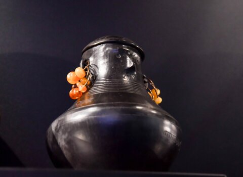 Zdjęcie. Urna twarzowa z kolczykami wykonanymi z paciorków burszytynowych