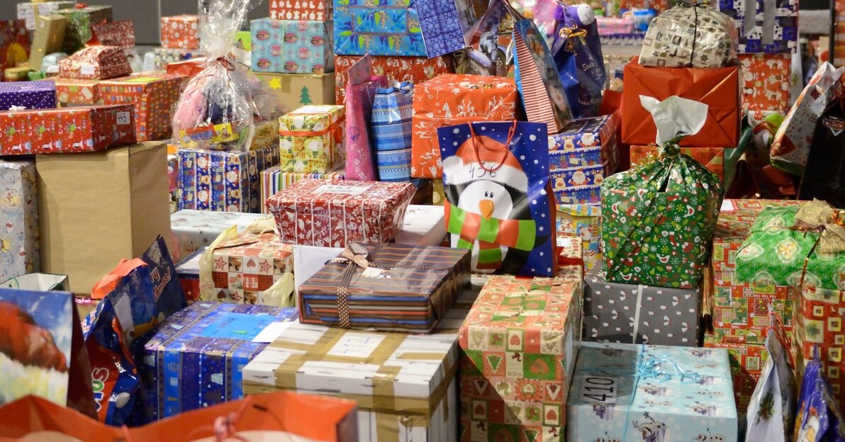 Finał jednej z edycji " Każdy może pomóc" - na zdjęciu mnóstwo świątecznie zapakowanych prezentów dla dzieci (prezenty ułożone na podłodze)