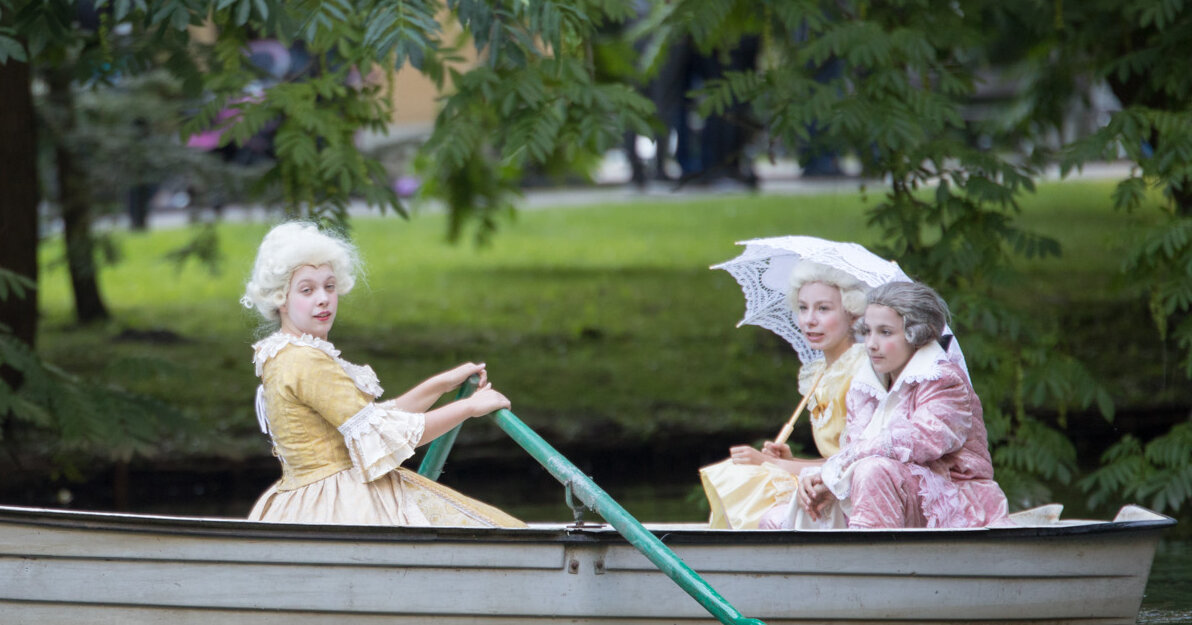 Dwie osoby w kostiumach nawiązujących do czasów Mozarta w łódce
