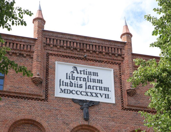 Artium Liberalium atudiis sacrum -Przybytek studiów nauk
wyzwolonych zdjęcie budynku z czerwonej cegły
