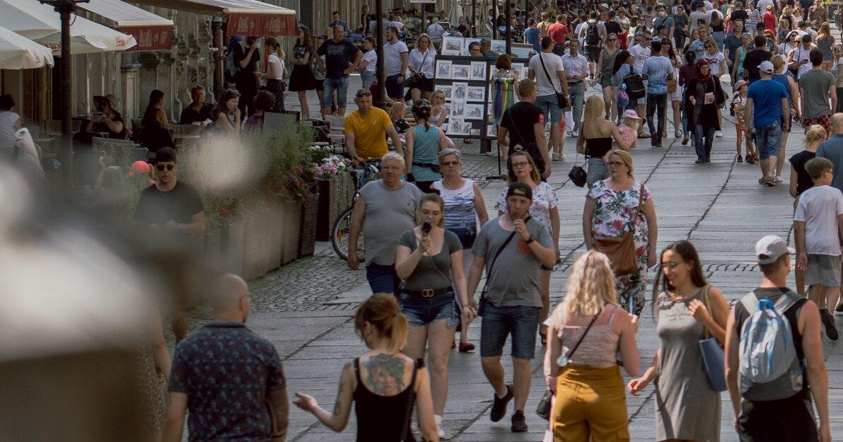 Na zdjęciu ul. Długa, po bokach widoczne kamienice, na ulicy spacerujący mieszkańcy i turyści.