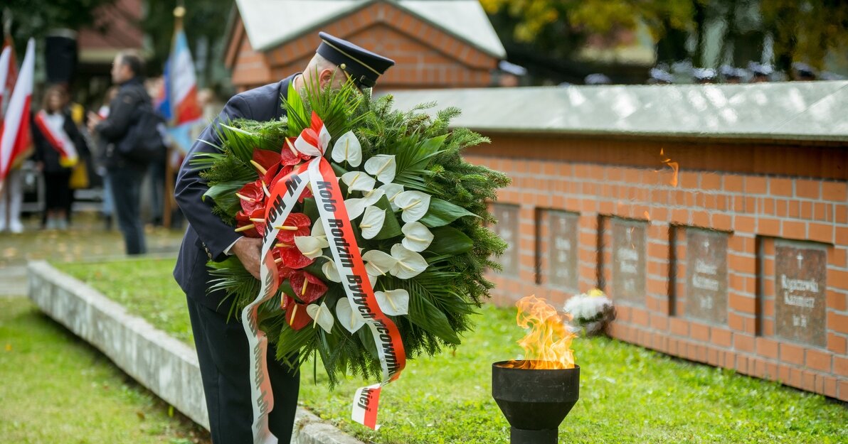 Na zdjęciu znajduje się przedstawiciel rodzin byłych pocztowców, składa biało-czerwony wieniec przy mogile zamordowanych Obrońców Poczty Polskiej. 