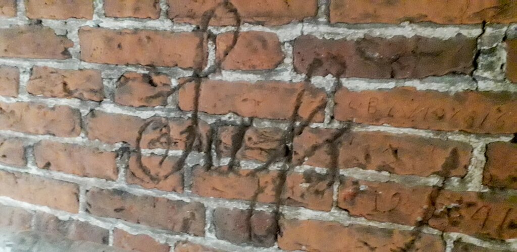 Zdjęcie przedstawia prawdopodobnie napis Jahs wyryty na cegłach. Jest to najpewniej nazwisko autora inskrypcji. Charakterystyczne dla XIX w. pismo pokrywa kilka cegieł. 