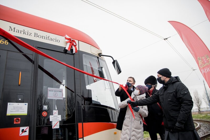 Odsłonięcie wstęgi. Gdańsk, ul. Witosa. Uroczystość nadania imienia Bonifacio D’oria gdańskiemu tramwajowi. W spotkaniu wezięli udział m.in. Piotr Borawski, zastępca prezydenta ds. przedsiębiorczości i ochrony klimatu, Anna Walczak, dyrektor Biblioteki Gdańskiej PAN, o. Tomasz Jank, gwardian klasztoru i rektor Kościoła Św. Trójcy.