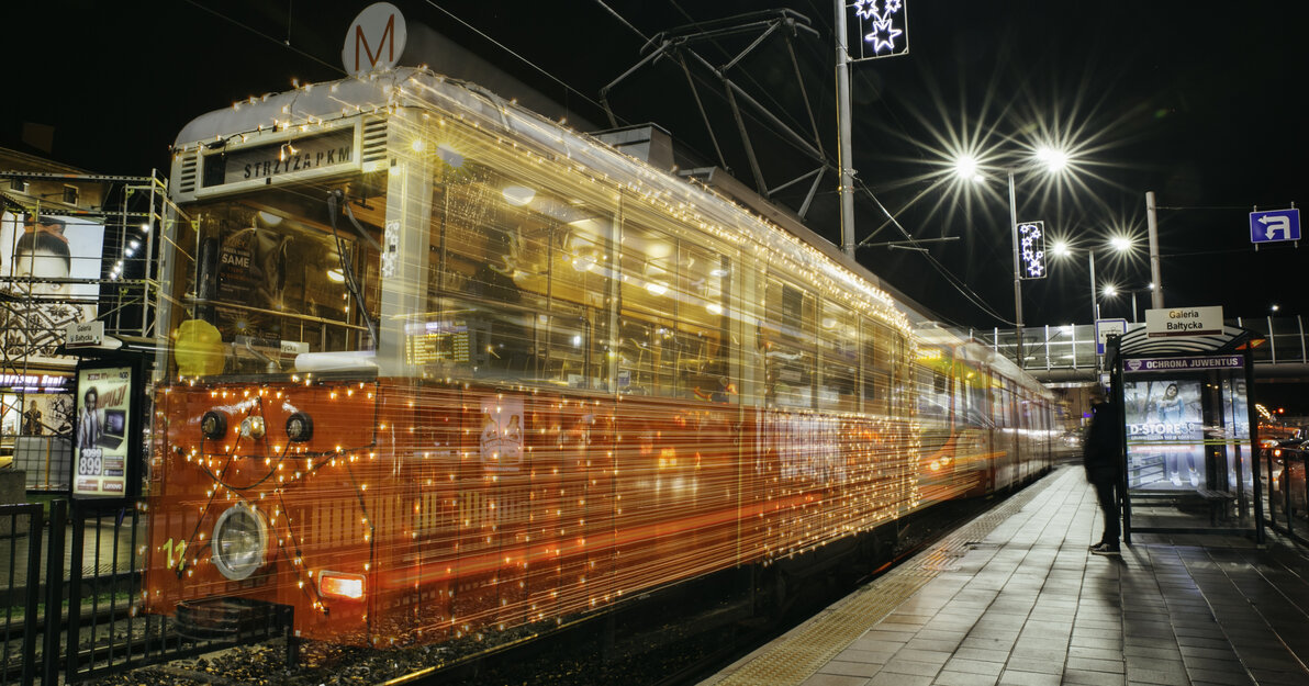 Przystrojony świątecznymi światełkami zabytkowy tramwaj przemierza gdańskie torowiska. 