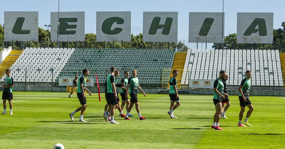 Rozgrzewka piłkarzy na boisku, w tle napis Lechia.