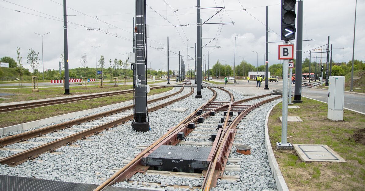 Węzeł integracyjny Ujeścisko, tory tramwajowe oraz w tle grupa ludzi ubrana w kaski i kamizelki ochronne