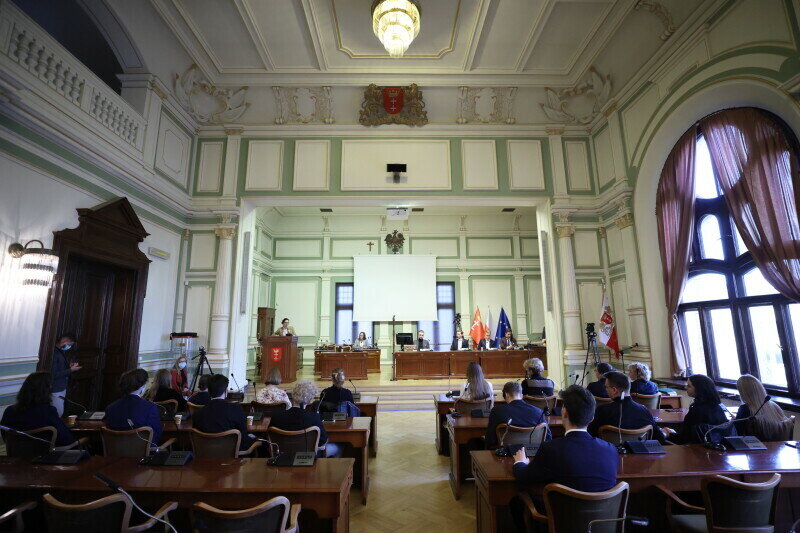 Sala obrad Rady Miasta. Na pierwszym planie młodzi radni w ławach, na drugim planie prezydium.