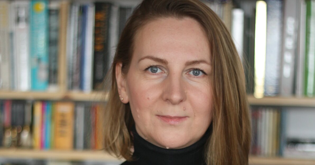 Monika Dylewska-Libera, nowa dyrektorka GAK, zdjęcie portretowe na tle regału z książkami. 